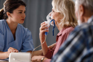 Woman Inhaling through nebulizer at doctor's office